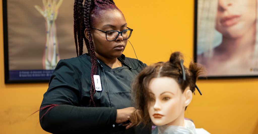Empire Beauty Schoo Student working on mannequin